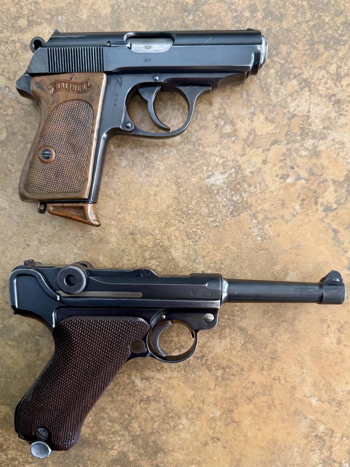 Reverse views of a 1935 Walther PPK and 1936 Mauser P.08 Luger